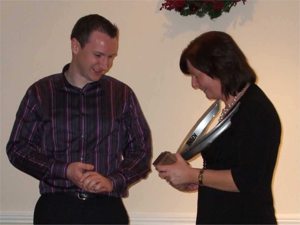 Mark Sheahan being presented with the broken wheel award by Club Secretary Mary Fitzgerald